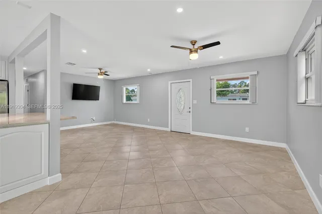 a large white kitchen with stainless steel appliances granite countertop a sink and cabinets