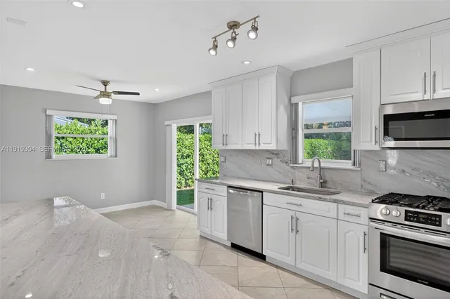 a large kitchen with stainless steel appliances granite countertop a lot of counter space and wooden floors