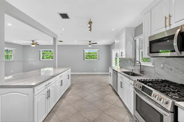 a kitchen with a stove a sink and a microwave