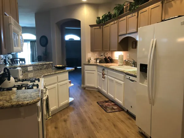 a kitchen with stainless steel appliances granite countertop a sink a stove and a refrigerator