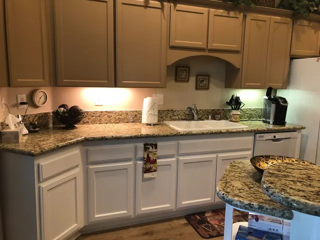 a kitchen with granite countertop a sink and cabinets