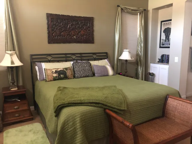 a bedroom with a bed and a lamp on dresser