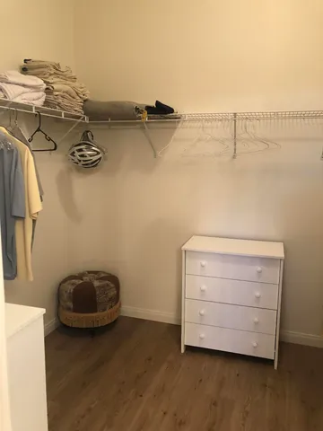 a view of walk in closet with clothes and shoes