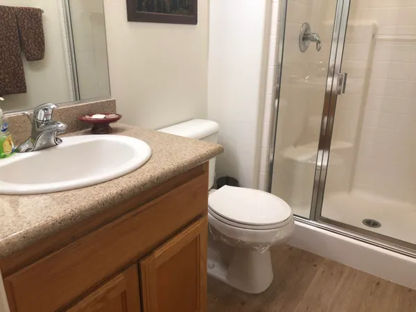 a bathroom with a sink a toilet and shower
