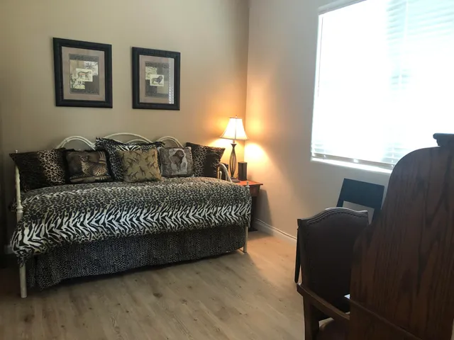 a living room with a couch wooden floor and a window