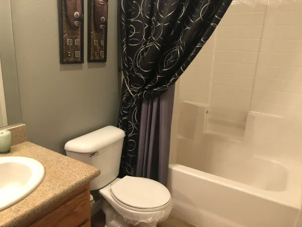 a white toilet sitting next to a bath tub and a shower