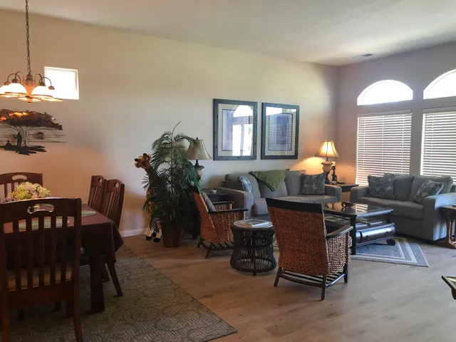 a living room with furniture a dining table and a chandelier