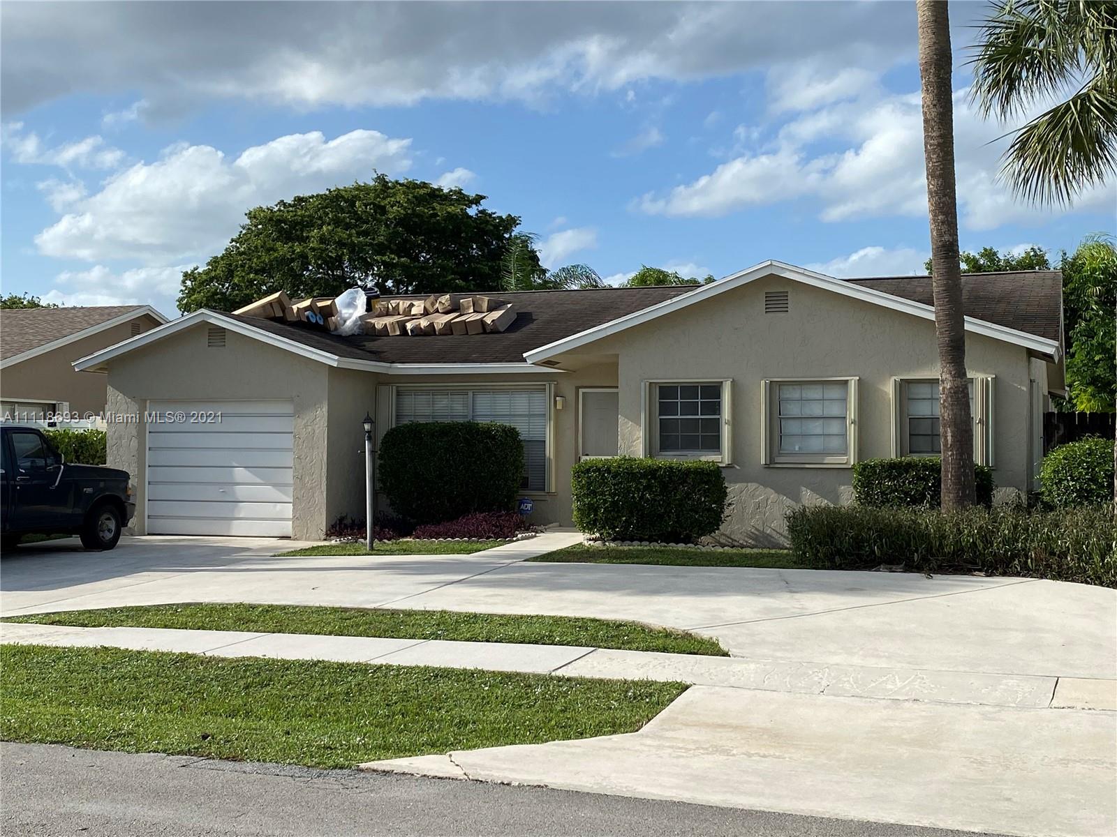 9191 Southwest 18th Road Boca Raton, FL 33428 - Photo 1 of 23 a front view of a house with a garden and yard