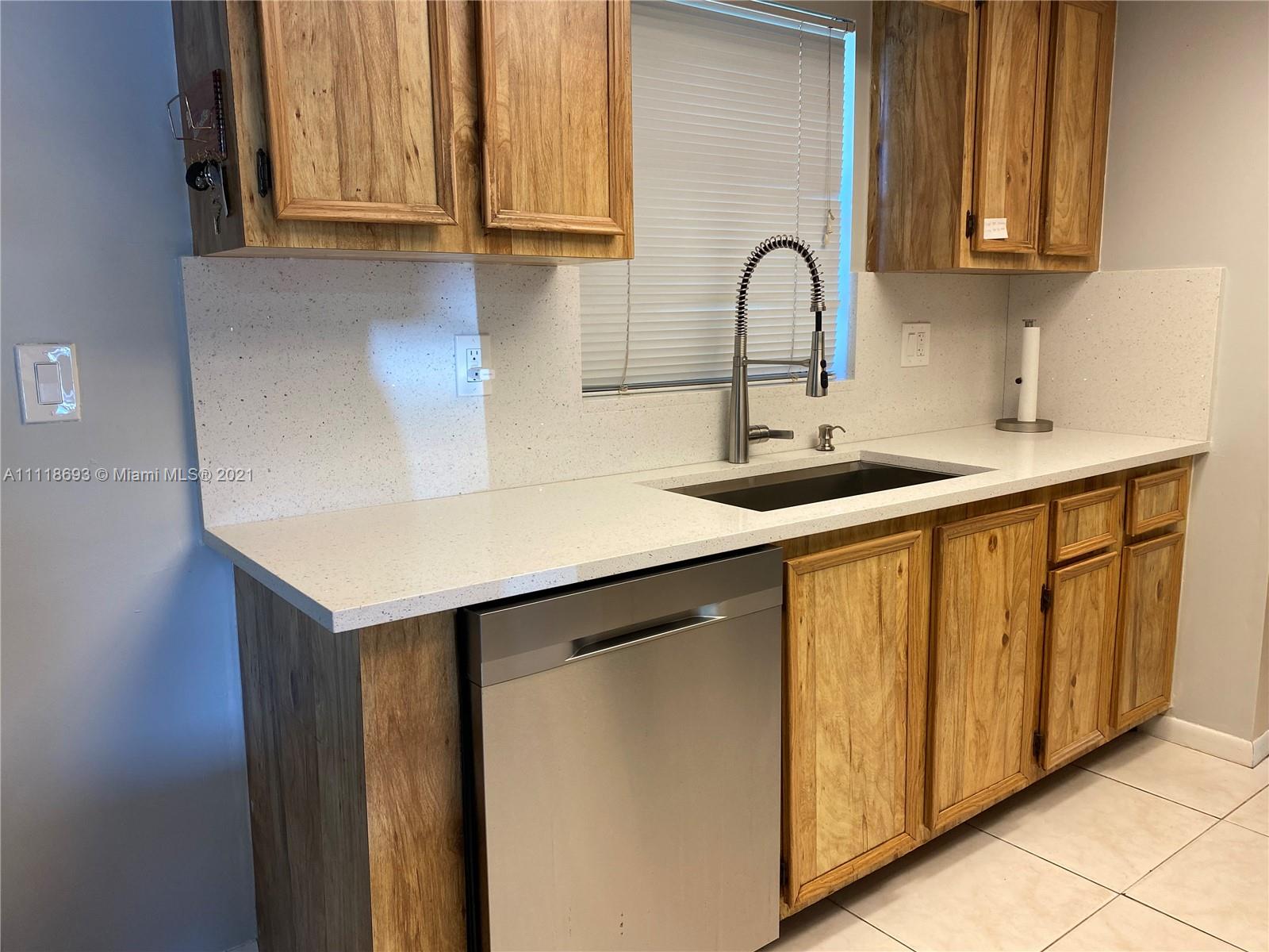 9191 Southwest 18th Road Boca Raton, FL 33428 - Photo 3 of 23 a kitchen with stainless steel appliances granite countertop a sink and cabinets