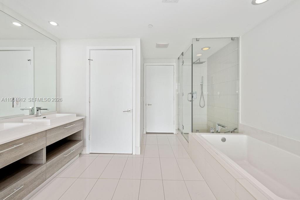 650 Northeast 32nd Street, Unit 2205 Miami, FL 33137 - Photo 9 of 56 a bathroom with a tub shower and sink