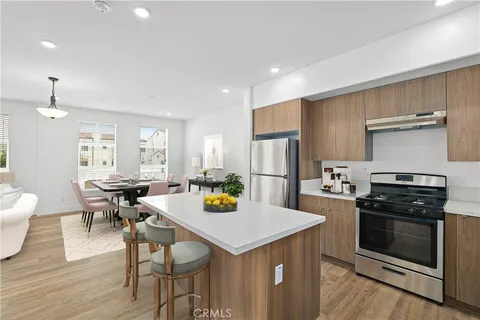 a kitchen with a stove a refrigerator and wooden floor