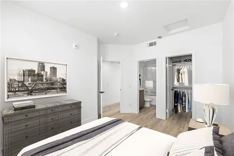 a bedroom with a bed and a mirror on the dresser