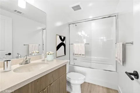 a bathroom with a sink mirror toilet and bathtub