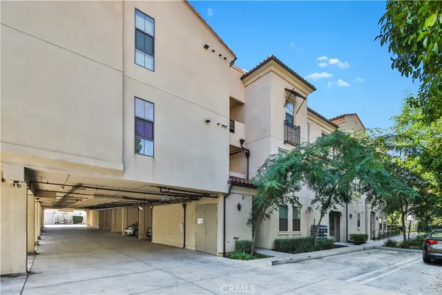 a view of a white house with a large tree and a yard
