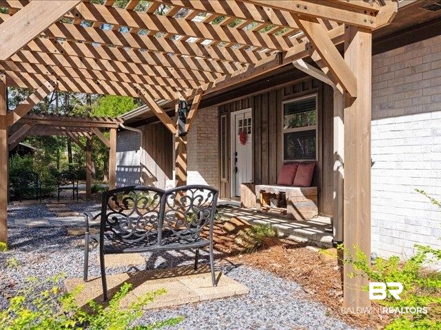 4650 Wiggins Lane Wilmer, AL 36587 - Photo 3 of 66 Doorway to property featuring brick siding, a pergola, and a patio area