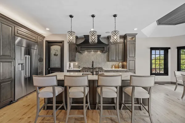 a kitchen with stainless steel appliances kitchen island granite countertop a dining table chairs and granite counter tops