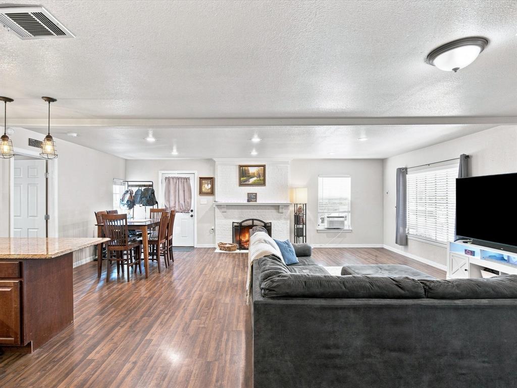 408 Inwood Road Azle, TX 76020 - Photo 9 of 32 Open-concept living space with wood-finish flooring, recessed lighting, and a white brick fireplace