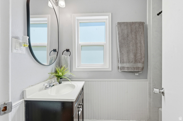 210 North 200 West Logan, UT 84321 - Photo 14 of 31 Bathroom vanity featuring a white countertop with integrated sink, chrome faucet, and dark wood-finish cabinetry