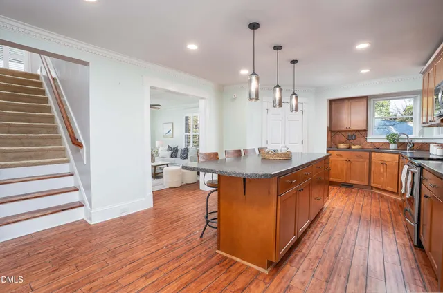a kitchen with stainless steel appliances granite countertop wooden floors and sink