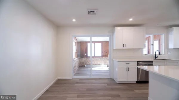a view of a kitchen with a sink wooden cabinets and window