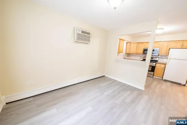 a view of a kitchen with wooden floor and electronic appliances