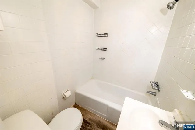 a white toilet sitting next to a bath tub