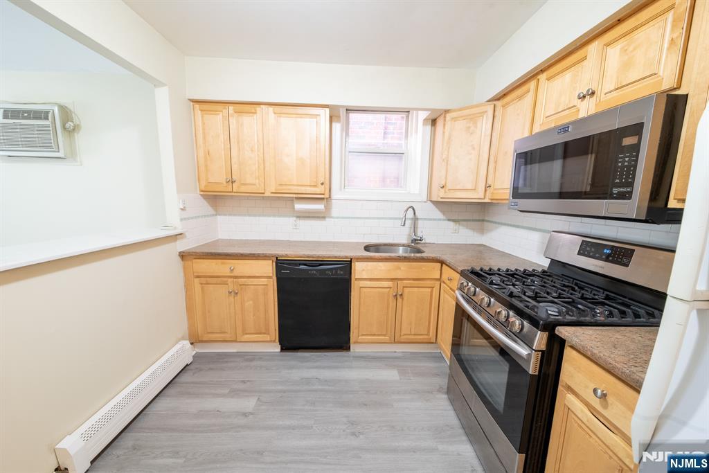 412 Walker Street, Unit 1 Fairview, NJ 07022 - Photo 6 of 10 a kitchen with stainless steel appliances granite countertop a stove a sink and a microwave
