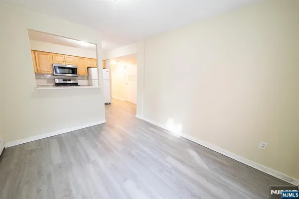 a view of a living room hardwood floor and a kitchen