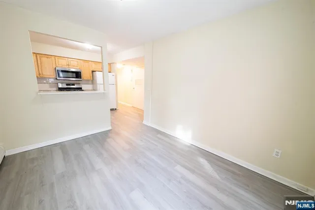 a view of a living room hardwood floor and a kitchen
