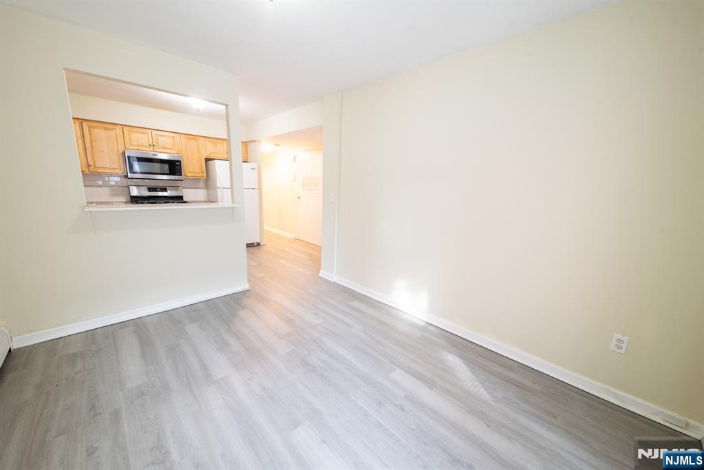 412 Walker Street, Unit 1 Fairview, NJ 07022 - Photo 7 of 10 a view of a living room hardwood floor and a kitchen