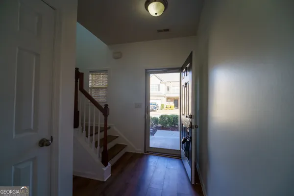 a view of a hallway with wooden floor and stairs