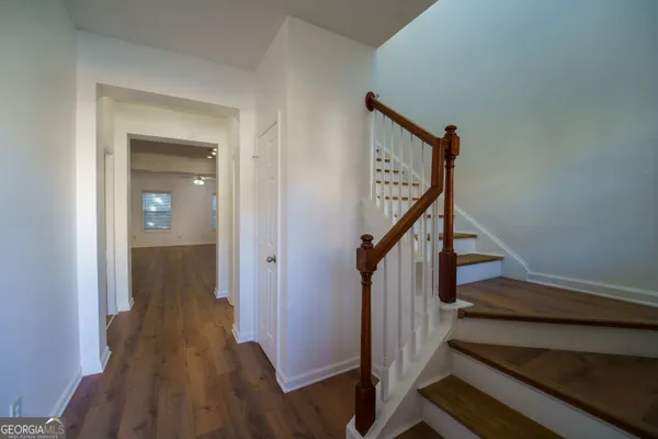 a view of a hallway with wooden floor and stairs