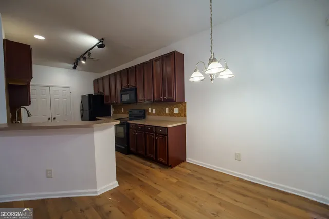 a kitchen with stainless steel appliances granite countertop a refrigerator a sink dishwasher a stove and a microwave oven on granite countertops