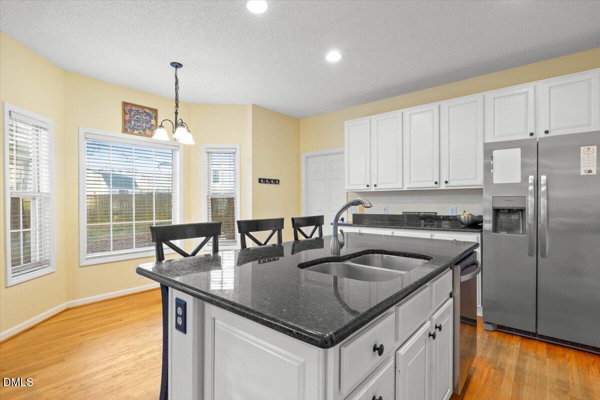6512 Cablewood Drive Raleigh, NC 27603 - Photo 13 of 41 a kitchen with stainless steel appliances granite countertop a sink a stove and a refrigerator