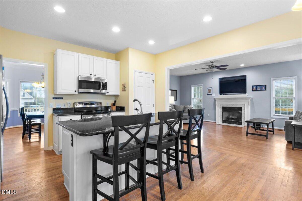 6512 Cablewood Drive Raleigh, NC 27603 - Photo 15 of 41 a kitchen with stainless steel appliances granite countertop a stove top oven a sink a dining table and chairs