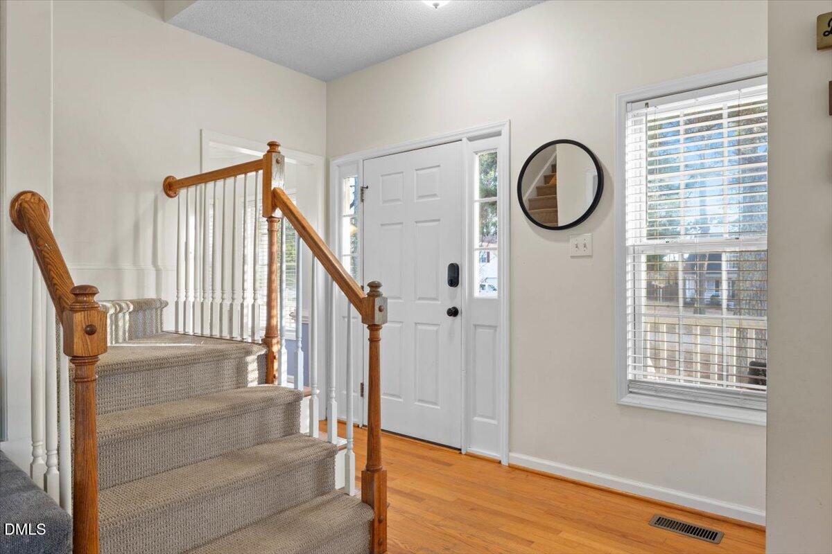 6512 Cablewood Drive Raleigh, NC 27603 - Photo 6 of 41 a view of a livingroom with wooden floor and windows
