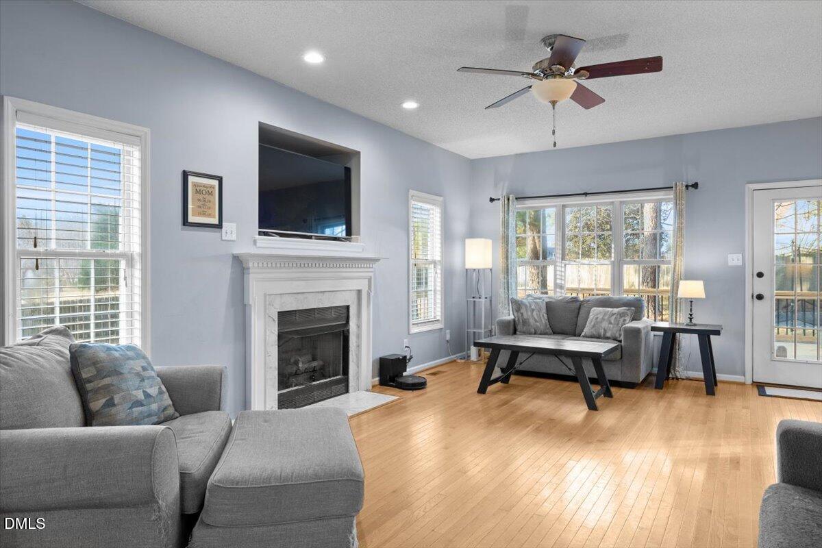 6512 Cablewood Drive Raleigh, NC 27603 - Photo 9 of 41 a living room with furniture a flat screen tv and a fireplace