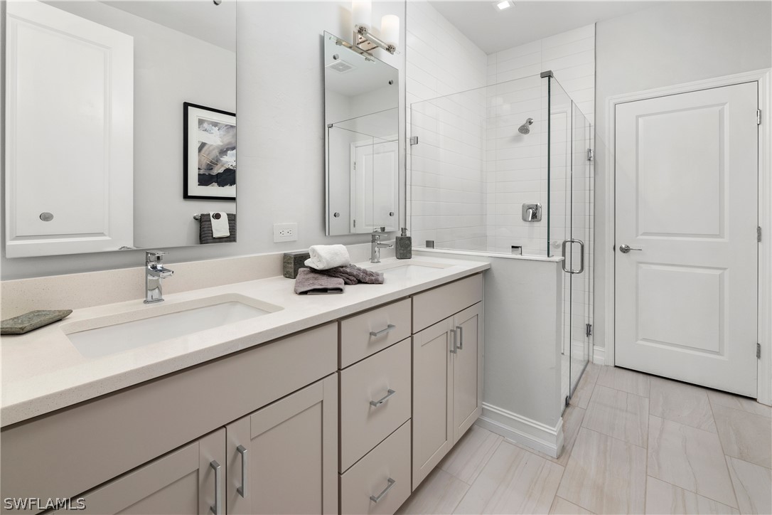7587 Morgan Way Naples, FL 34119 - Photo 14 of 29 a bathroom with double sink and a mirror