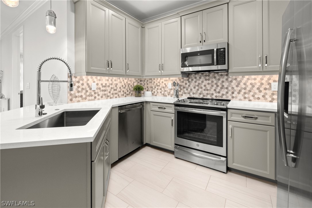 7587 Morgan Way Naples, FL 34119 - Photo 8 of 29 a kitchen with white cabinets stainless steel appliances and sink