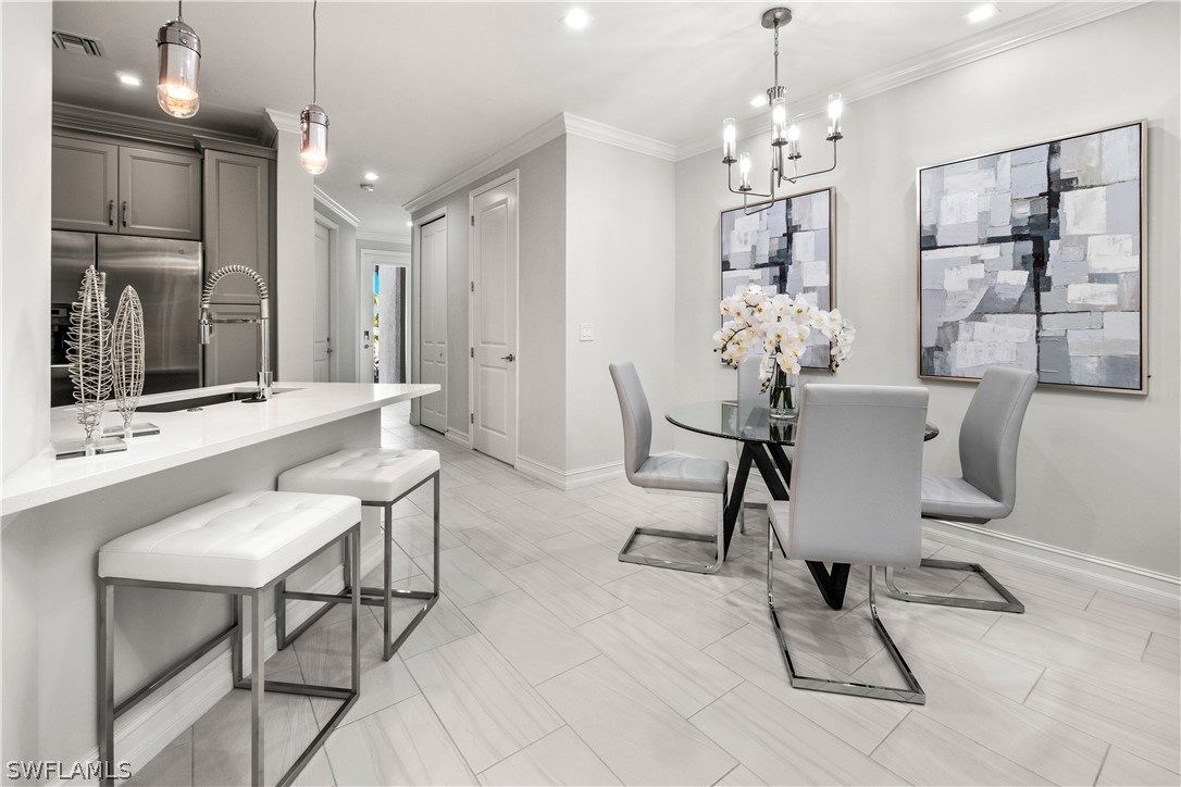 7587 Morgan Way Naples, FL 34119 - Photo 9 of 29 a view of a dining room with furniture and chandelier