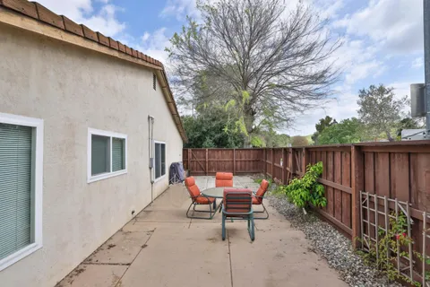 a backyard of a house with chairs and table