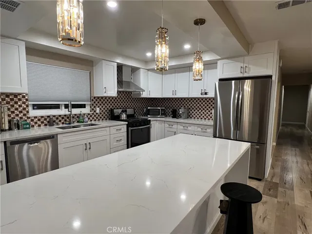 a kitchen with stainless steel appliances granite countertop a sink stove and refrigerator
