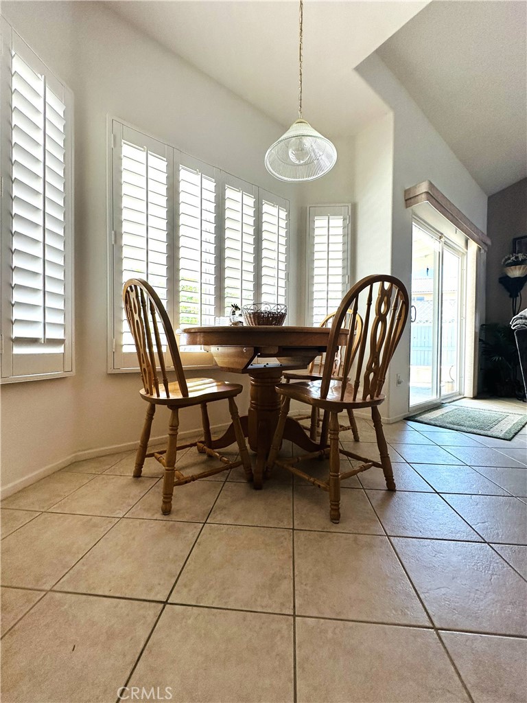 1665 Ravenswood Road Beaumont, CA 92223 - Photo 15 of 41 a view of a dining room with furniture and chandelier
