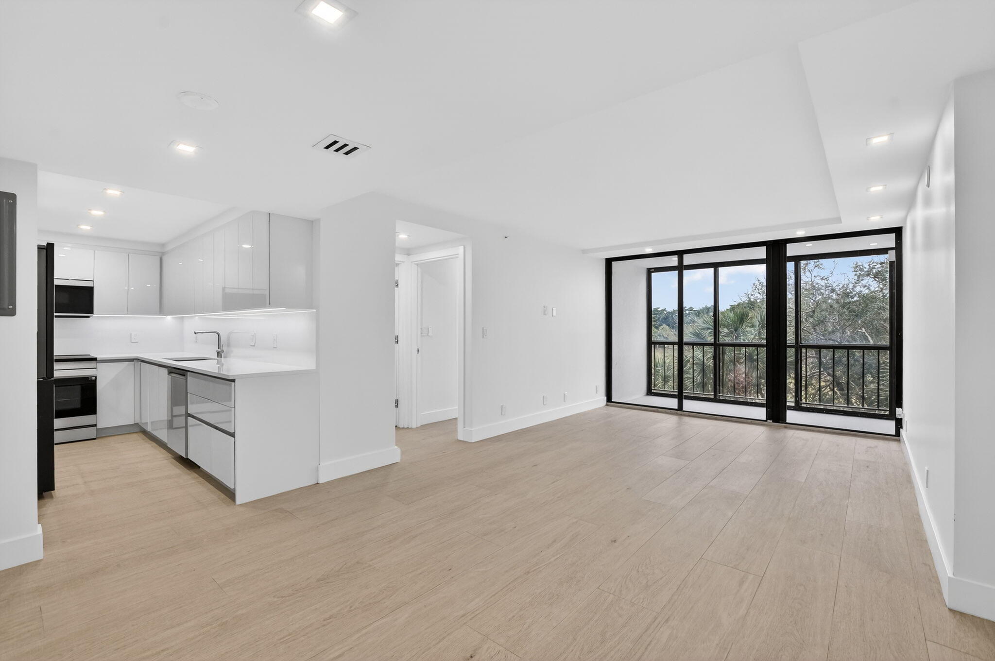 a view of large kitchen with stainless steel appliances kitchen island large windows and cabinets