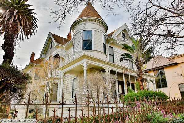 a view of a multi story residential apartment building with a yard and potted plants