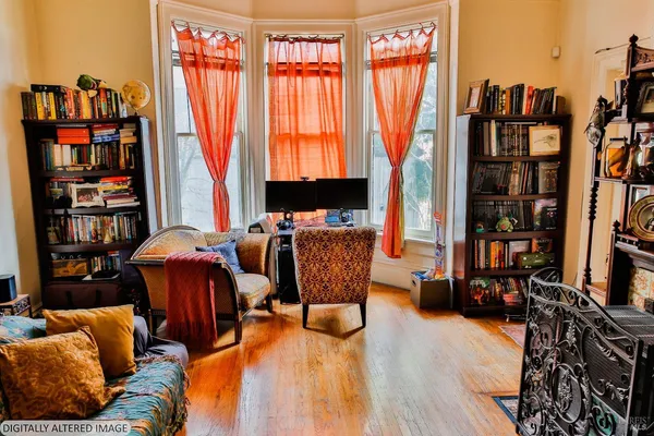 a living room with furniture a bookshelf and a window
