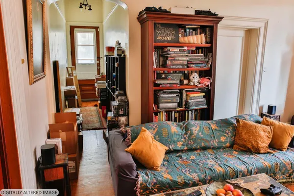 a living room with furniture and a book shelf