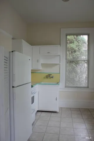 a white refrigerator freezer sitting in a kitchen