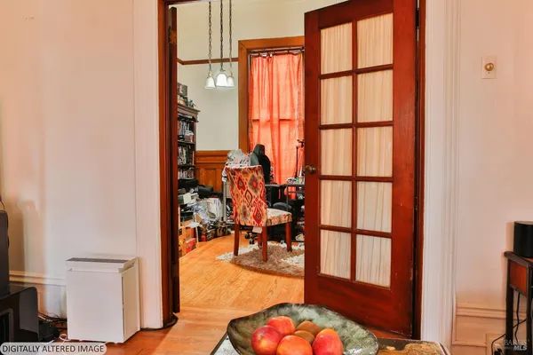 a view of a living room with a floor to ceiling window and wooden floor