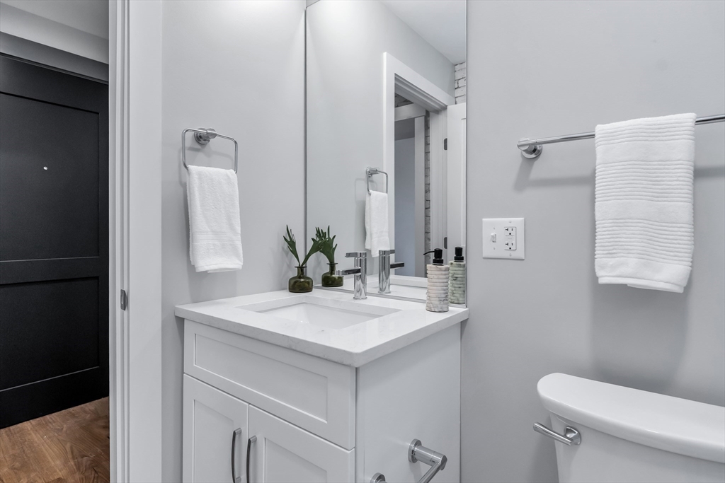 200 Merrimack Street, Unit 202 Haverhill, MA 01830 - Photo 12 of 13 a bathroom with a granite countertop sink and a mirror with toilet